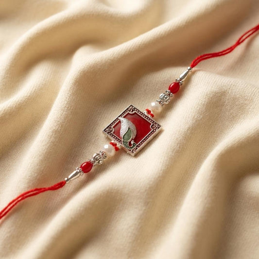 Traditional Silver Peacock Feather Rakhi with Red & Pearl Beads