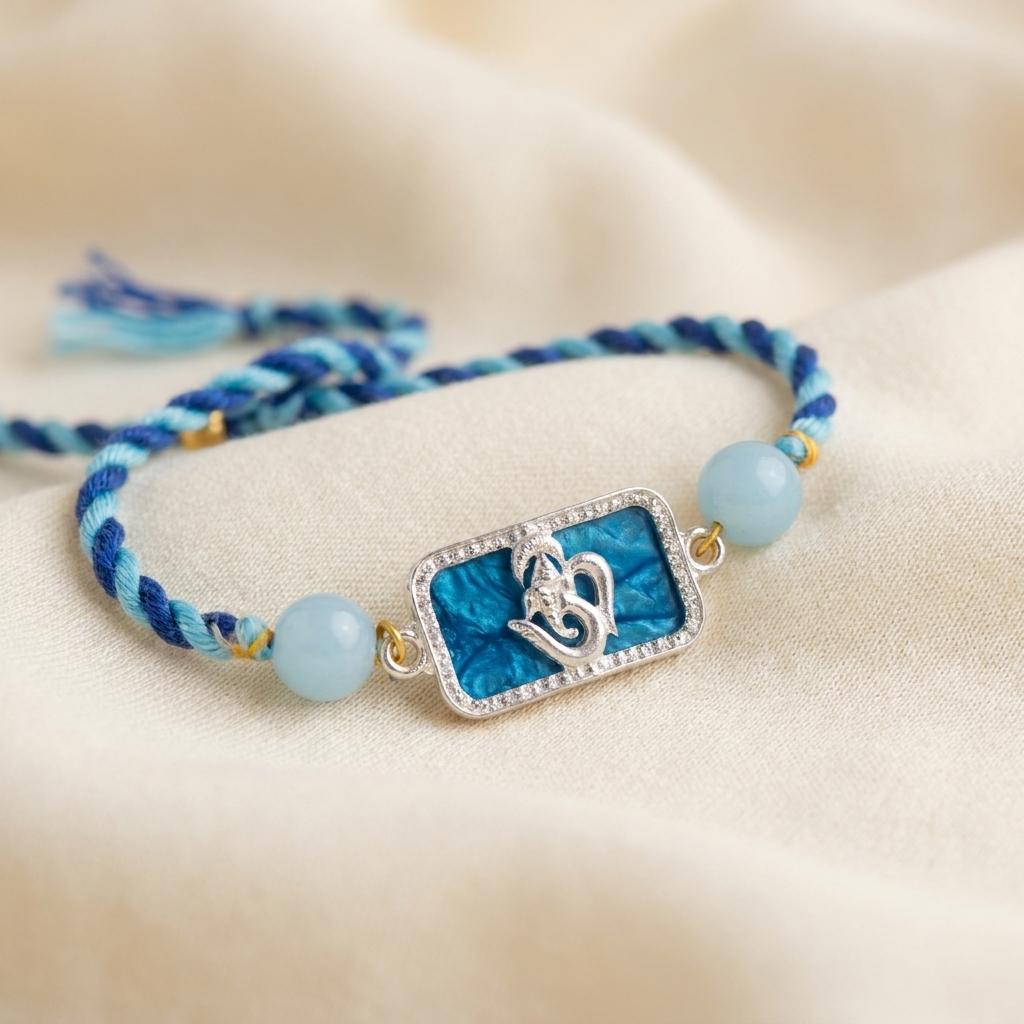 Silver Om Ganesh Motif Rakhi with Blue Braided Thread