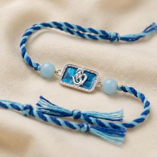 Silver Om Ganesh Motif Rakhi with Blue Braided Thread