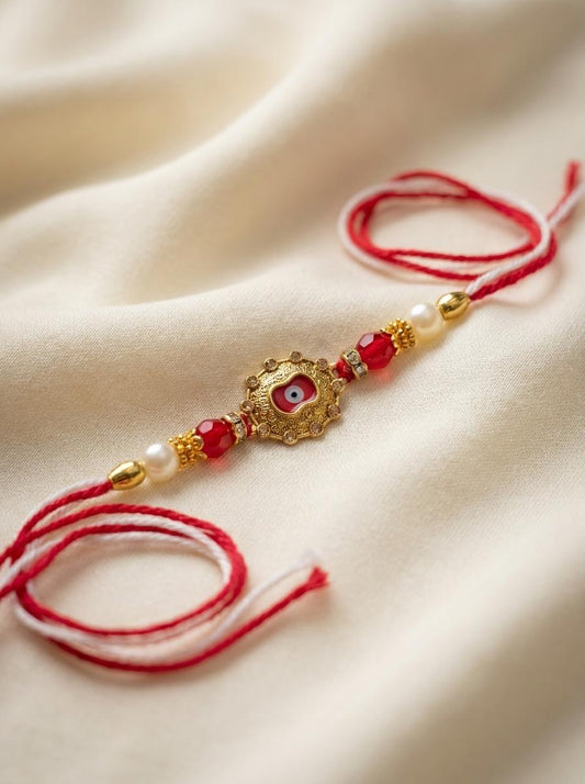 Ornate Evil Eye Gold Rakhi with Pearl & Red Crystal Beads