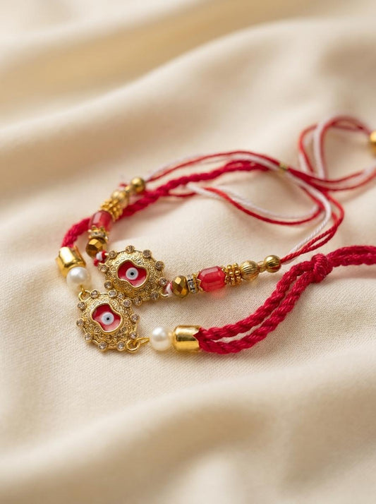Ornate Evil Eye Gold Rakhi with Pearl & Red Crystal Beads