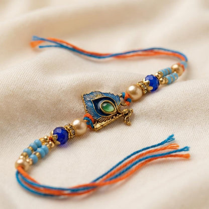 Elegant Krishna Bansuri & Mor Pankh Rakhi with Blue Beads - selfie to print