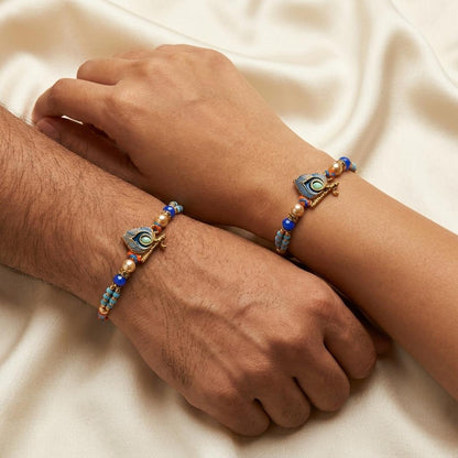 Elegant Krishna Bansuri & Mor Pankh Rakhi with Blue Beads - selfie to print