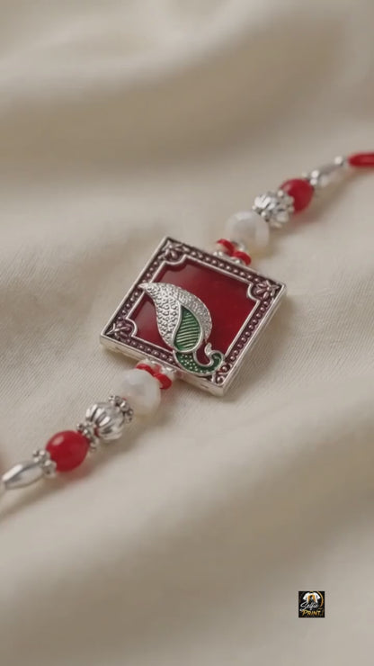 Traditional Silver Peacock Feather Rakhi with Red & Pearl Beads